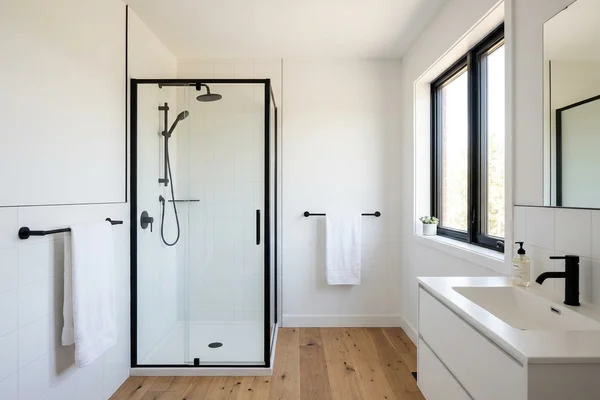 Finished multiplex bathroom with white tile and matte black fixtures